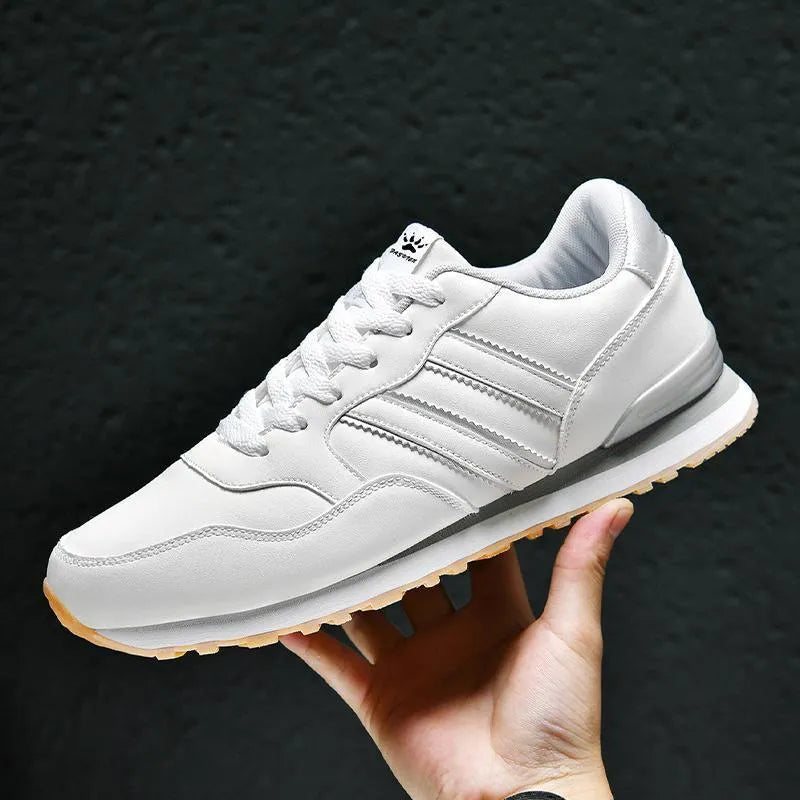 Men's black leather casual shoes with a carved wing pattern design and a white mesh tongue.