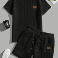 Men's black sports two-piece set with ribbed short sleeve top and matching trousers for athletic activities