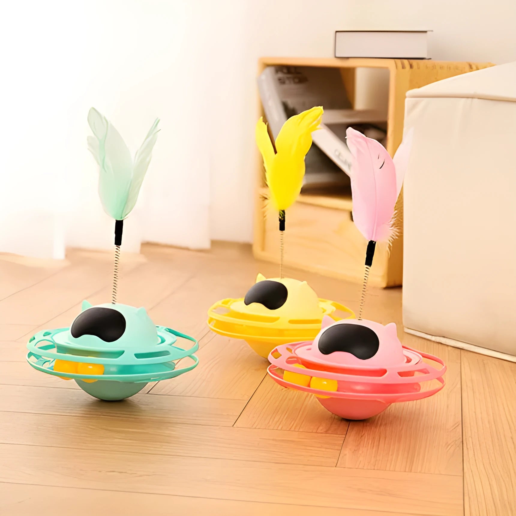 Pink cat tumbler turntable toy with feather attachments on rotation platform