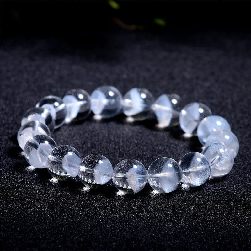Women's natural white crystal bracelet with a pyramid charm and ruyi charm, showing spherical beads.