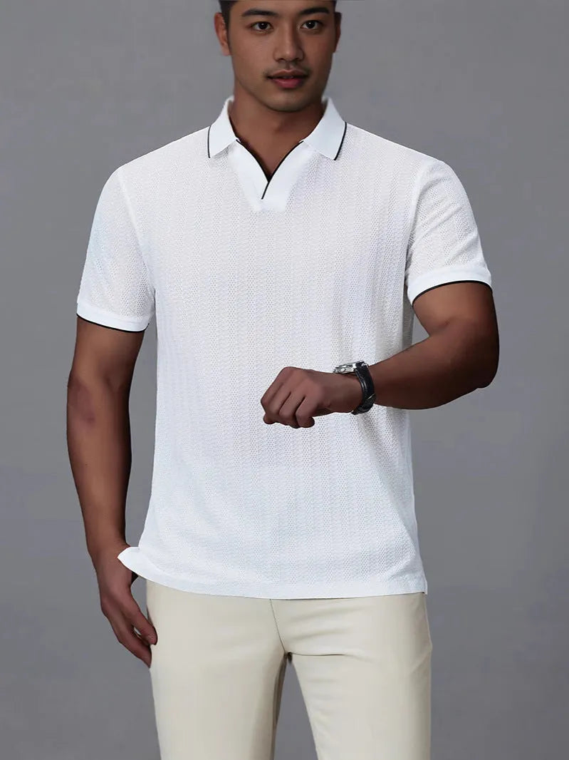 Man wearing a black loose-fit short-sleeved nylon polo shirt on a casual background.