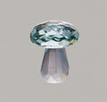 Handcrafted white crystal mushroom decoration in four colours on a wooden surface.