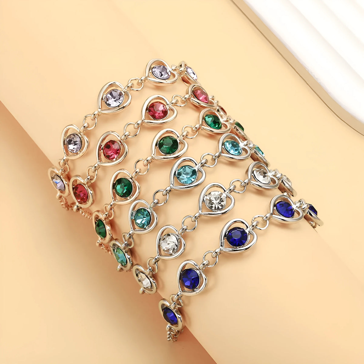 Heart shaped alloy bracelet with crystal inlay, shown in a choice of seven colours including sapphire blue and light purple.