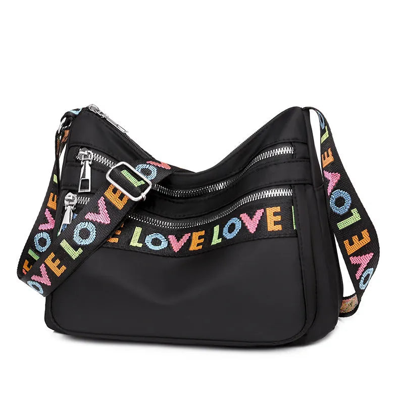 Oxford cloth crossbody shoulder bag in red or black with multi-pocket design, single strap, polyester lining, and letter stitching detail.