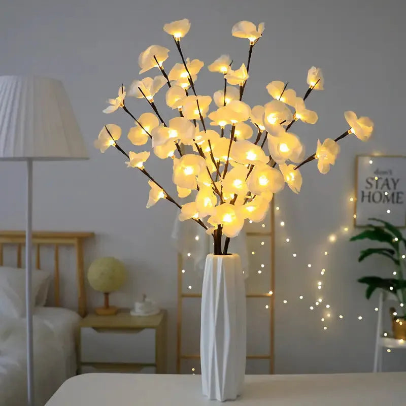 Pink fabric-covered LED Phalaenopsis orchid branch light, 65cm long, with warm white bulbs illuminated on a dark surface.