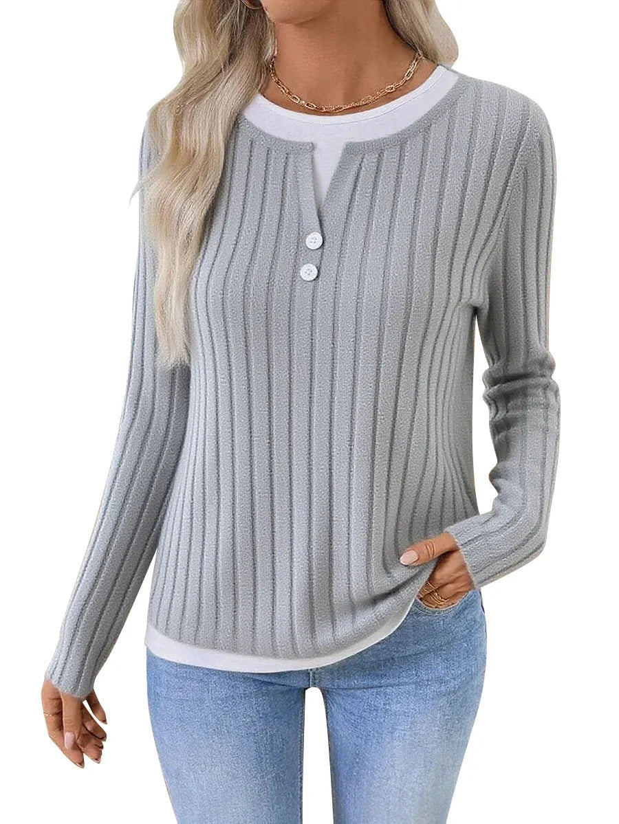 Women's black fake two-piece pullover sweater with round neck, button, and long sleeves on a hanger.