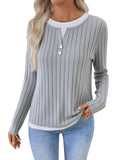 Women's black fake two-piece pullover sweater with round neck, button, and long sleeves on a hanger.
