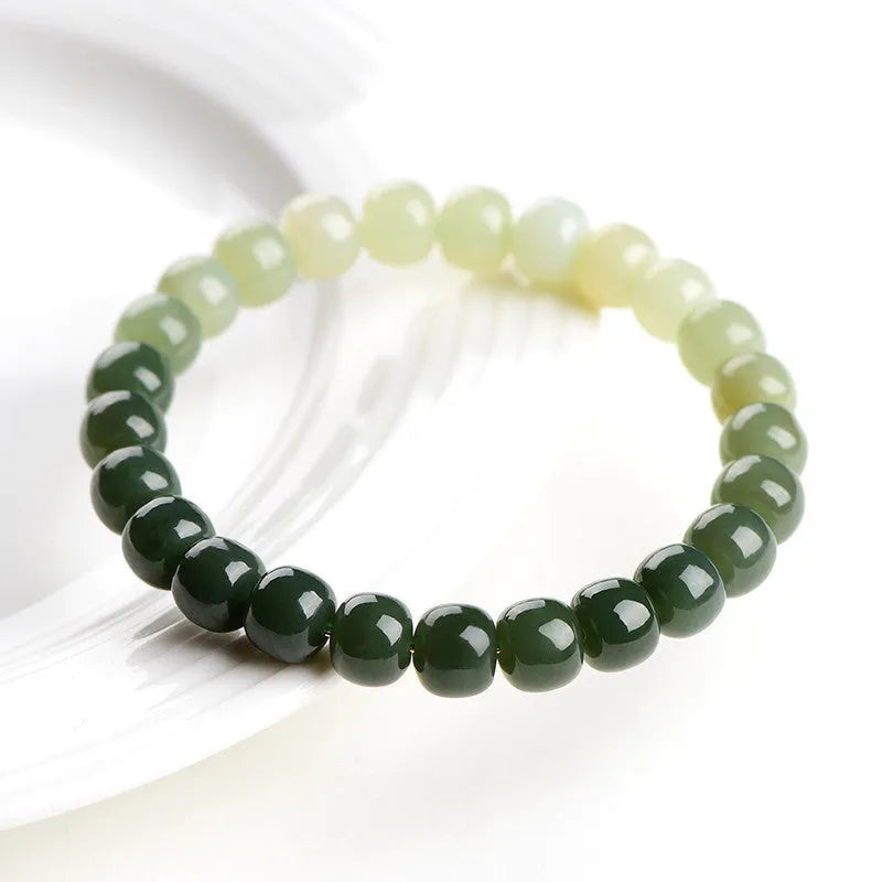 Natural Hetian jade bracelet with sunny water gradient colour on a wrist, showing oval beads.