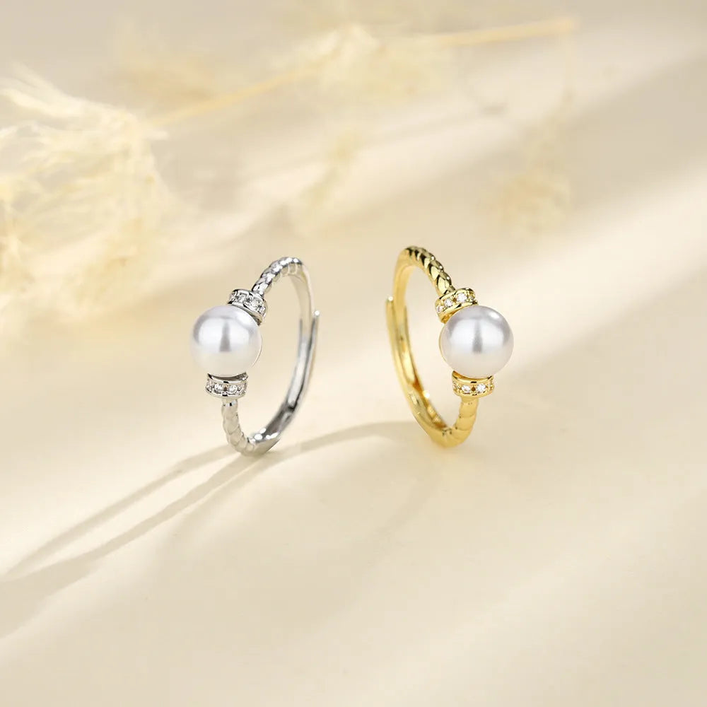 Adjustable antique-finish copper ring with a 6mm pearl set in a geometric twist.