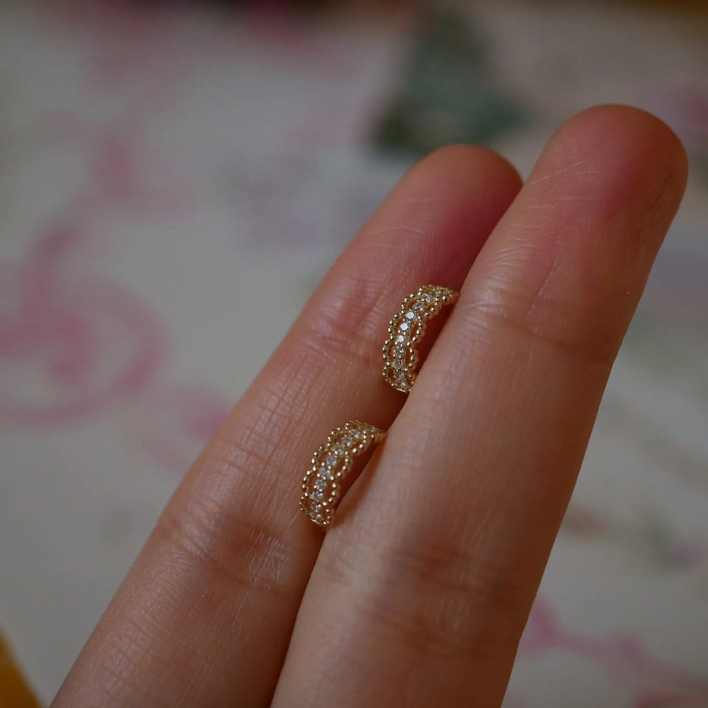 Small lace pattern ear clips in gold or platinum colour on ear model