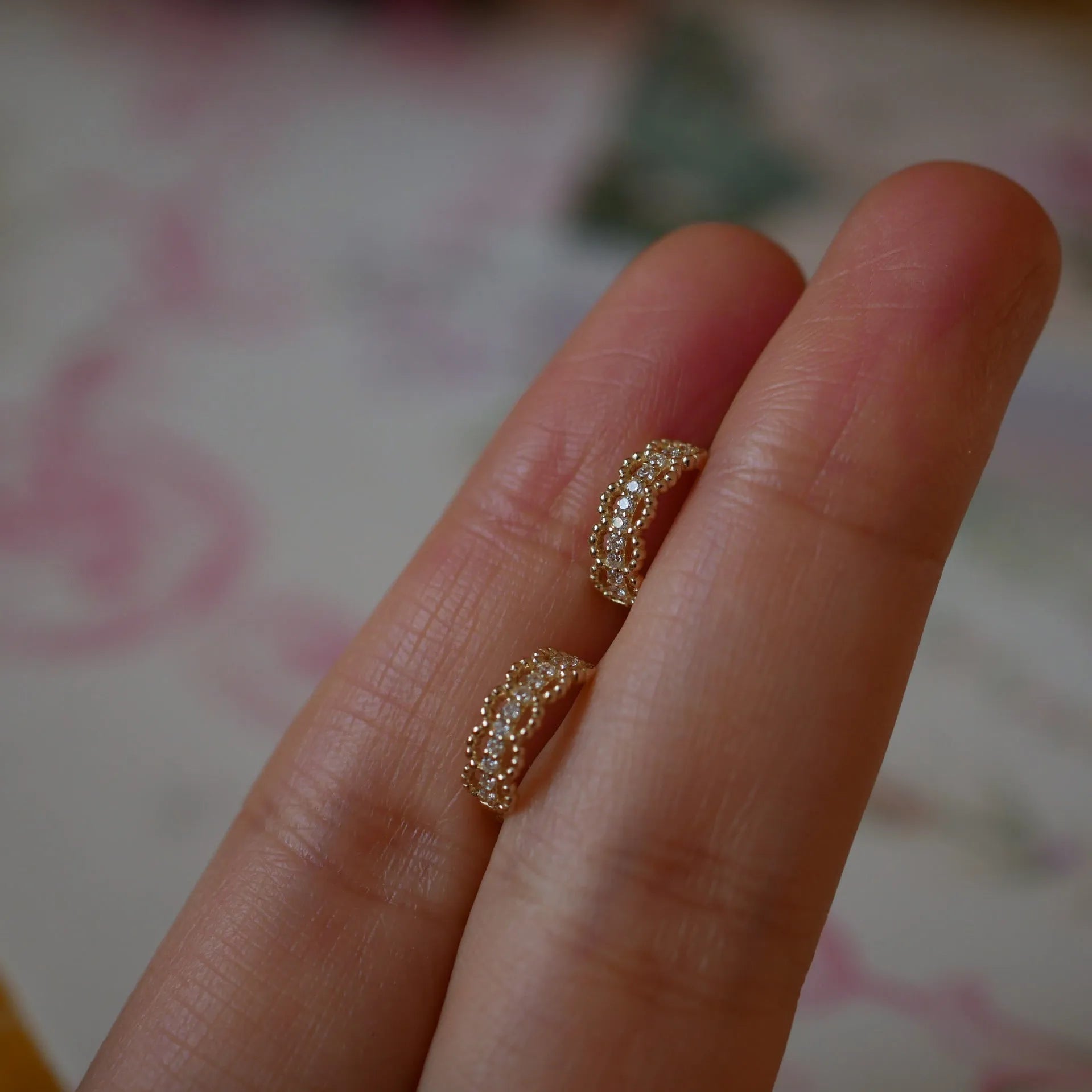 Small lace pattern ear clips in gold or platinum colour on ear model