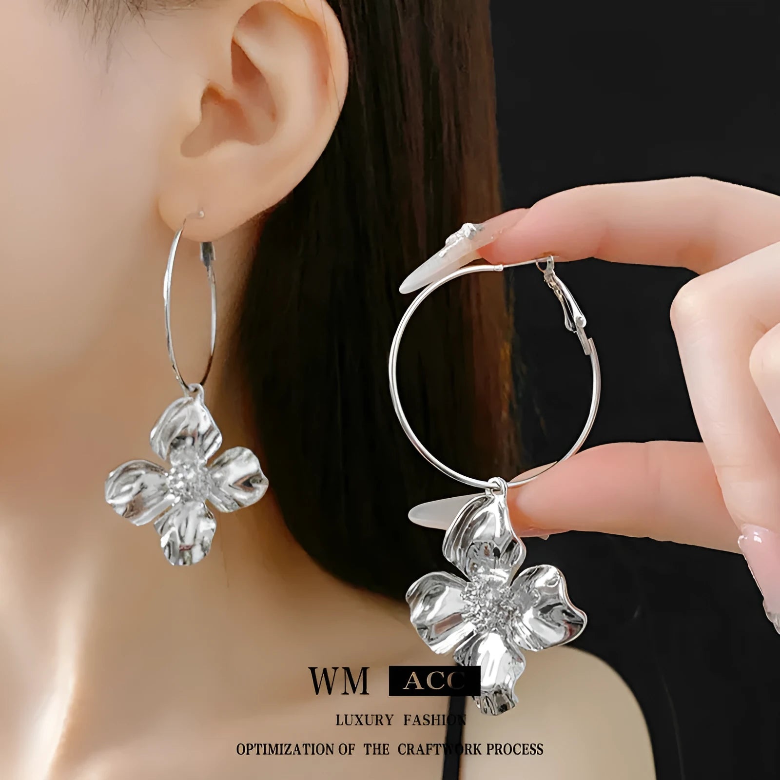 A pair of geometric flower-shaped metal earrings with a silver needle detail, shown in gold and silver electroplated finishes.
