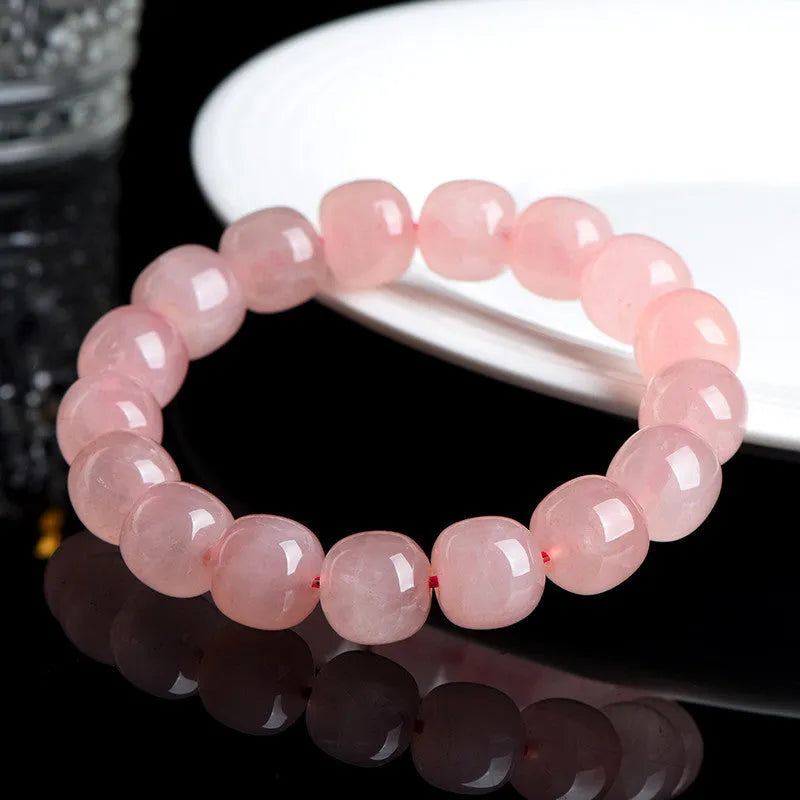 Pink natural crystal barrel bead bracelet with geometric design on wrist