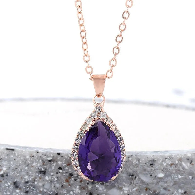 Rose gold water drop shaped necklace with geometric design and rhinestone accents in pink colour