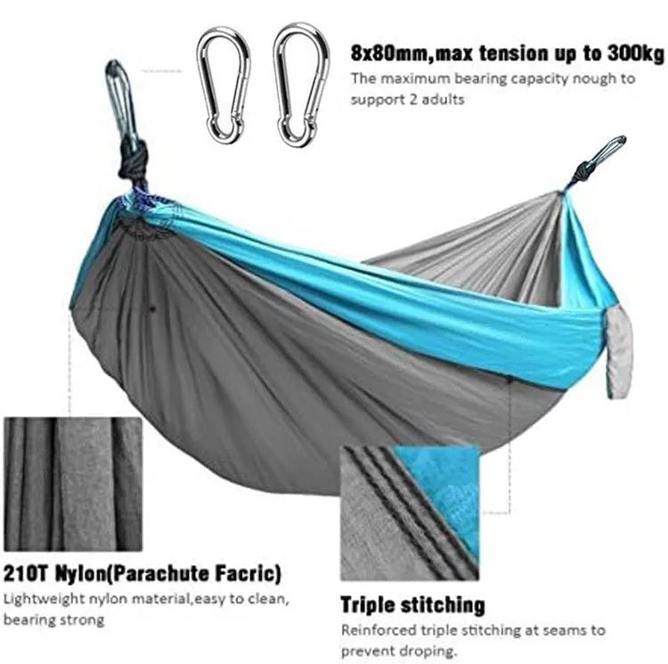 Sapphire blue parachute nylon hammock hung between two trees, showing its full 270cm length and integrated ropes.