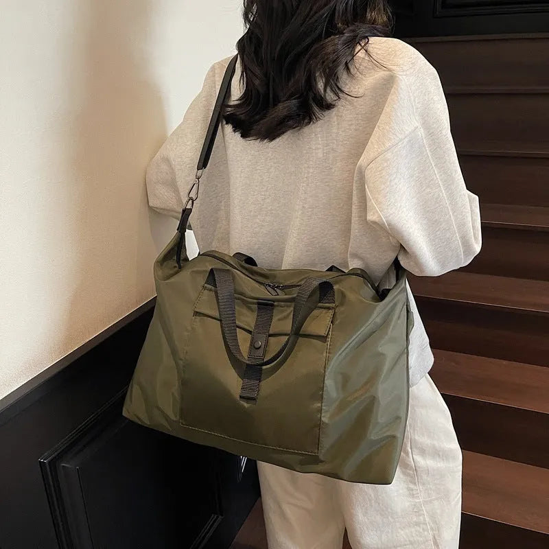 Large one-shoulder travel bag in Oxford cloth showing black, grey, and green colour options.