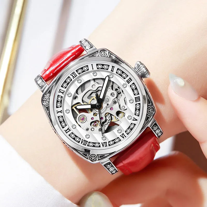 Mechanical watch with luminous hands and a black leather strap on a wrist.