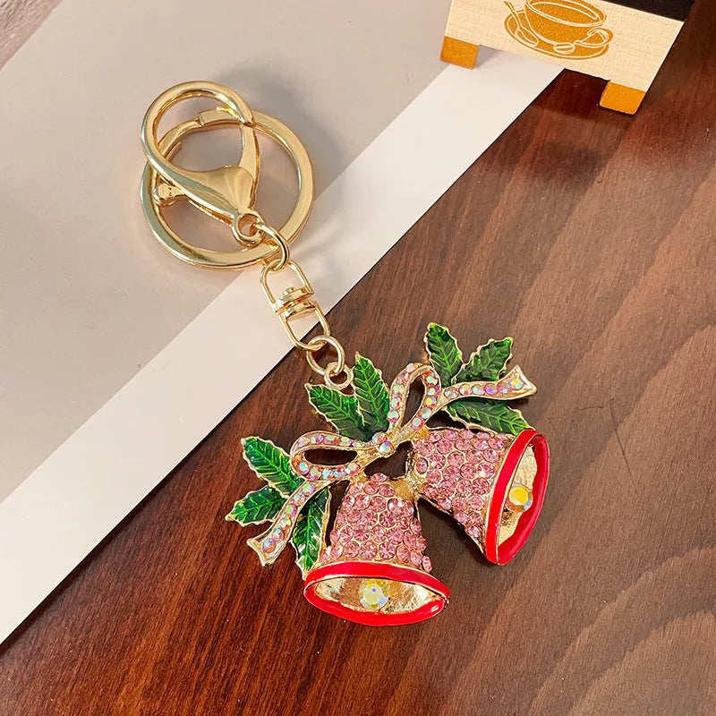 Diamond studded metal Christmas bell keychain in European style on a white background