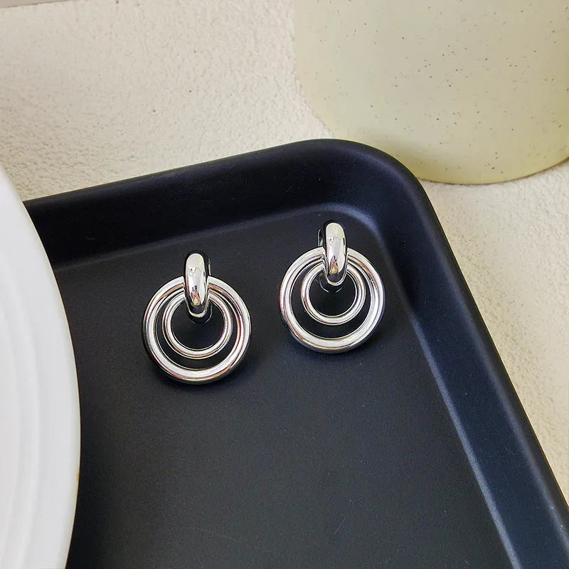 Geometric round ring earrings with irregular shape in gold electroplated finish on mixed material