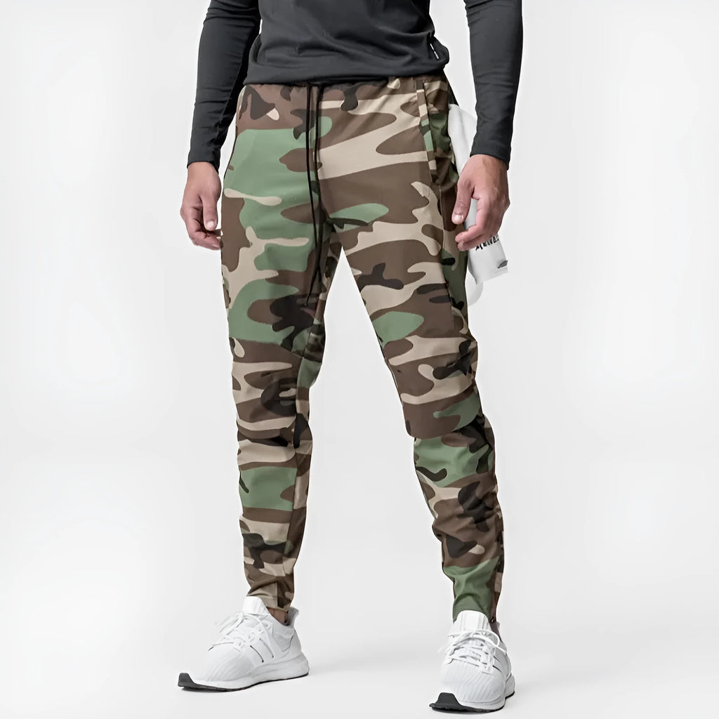 Man wearing dark grey loose-fit fitness trousers with tied ankle cuffs, suitable for gym training.