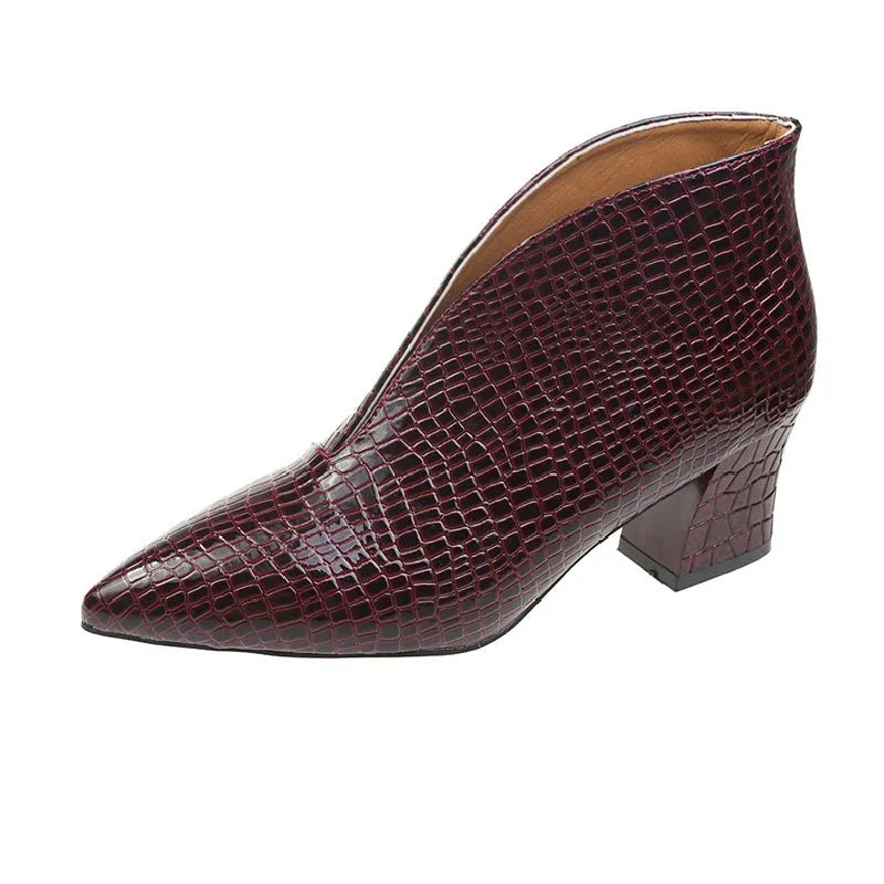 Women's black V-cut pointed toe Martin boots with embossed detail and a chunky heel.