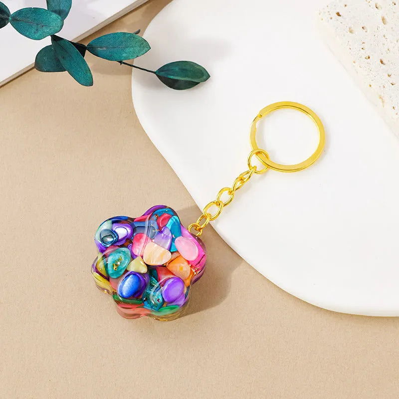 Small cat's paw shaped keychain pendant made from a natural pink crystal on a metal ring.