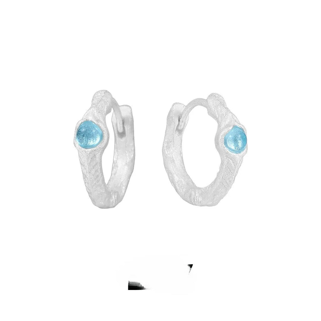 Geometric round ear clips in burnt silver colour on a white background