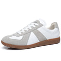 White Japanese-style retro low-top sneakers with round toe and flat rubber sole on a plain background.
