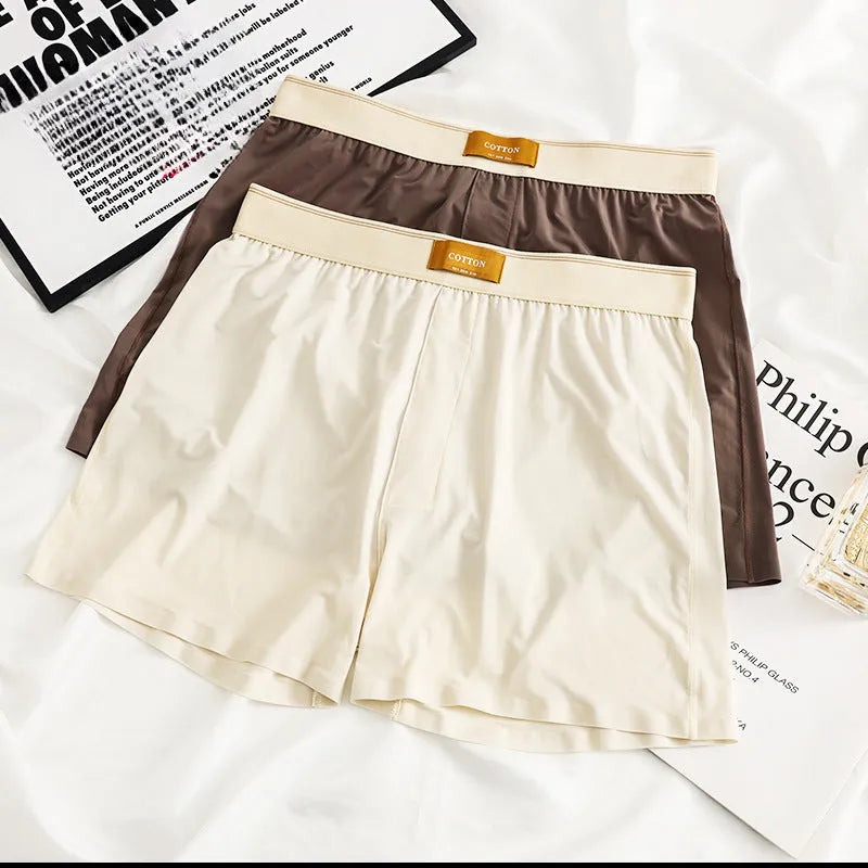 Men's solid colour loose ice silk underwear in beige, black, and grey shades laid flat