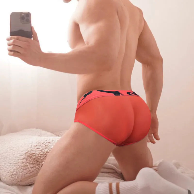 Men's solid colour modal boxer shorts with a low waist design, shown in black, pink, and red.
