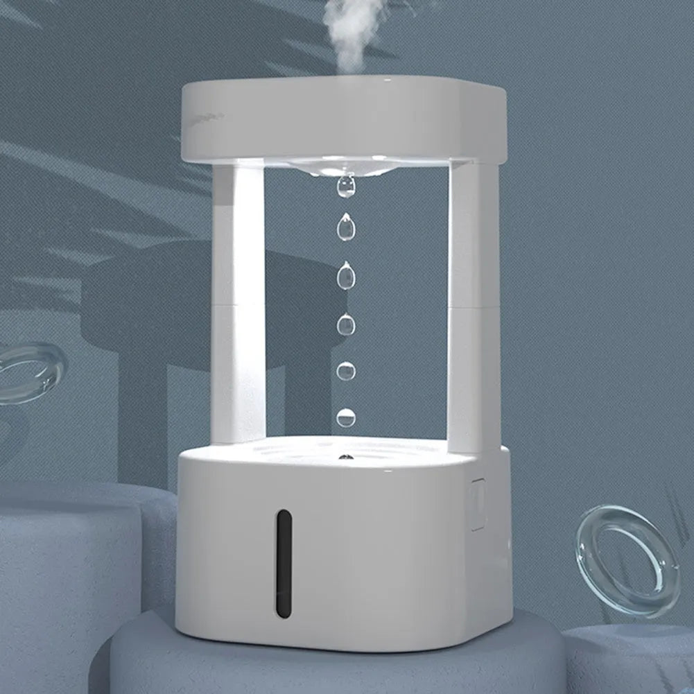 White anti-gravity water drop humidifier with coloured light on a desk next to USB cable