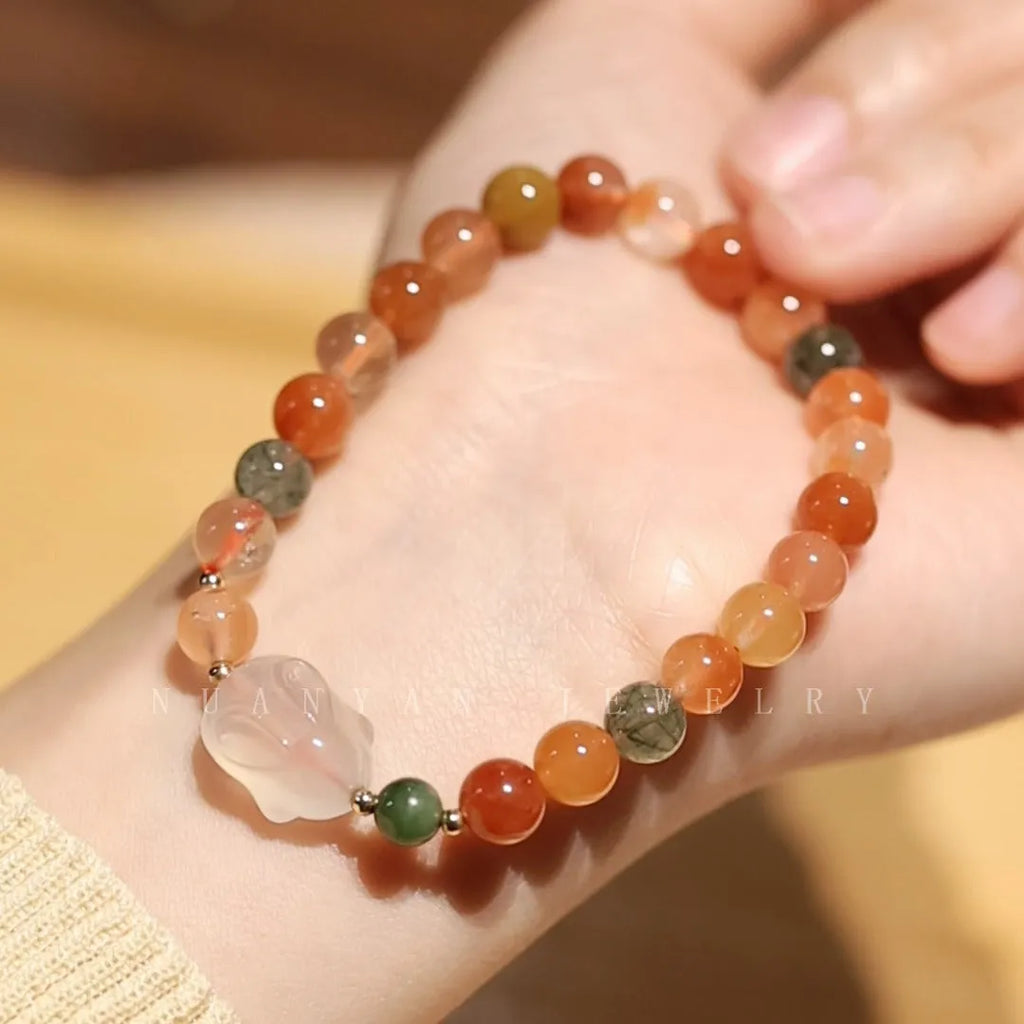 Close-up of a women's handmade bracelet with a detailed jade rabbit charm in a gift box.