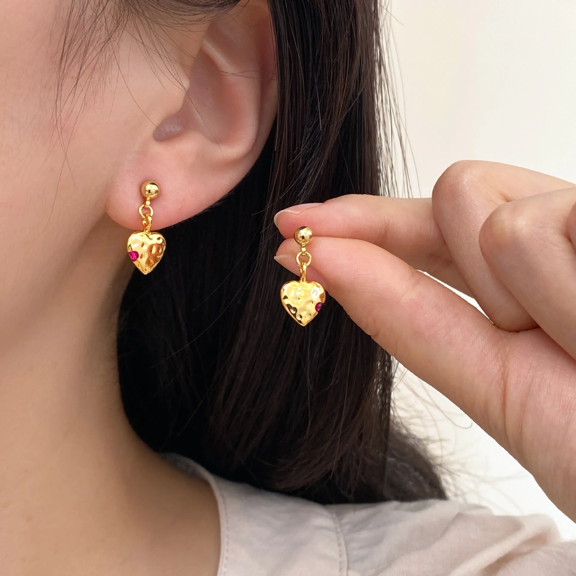 Pair of simple heart-shaped copper earrings with electroplated finish, available as ear clips or studs