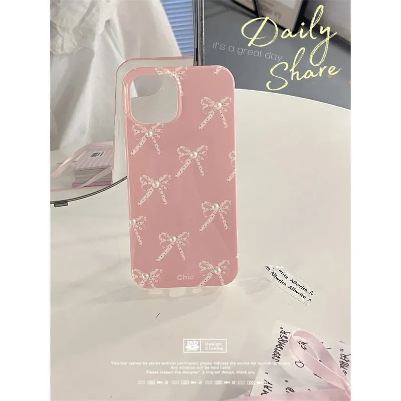 Pink soft TPU iPhone case with three-dimensional pearl dot bow, compatible with iPhone 11 to 15 Pro Max.