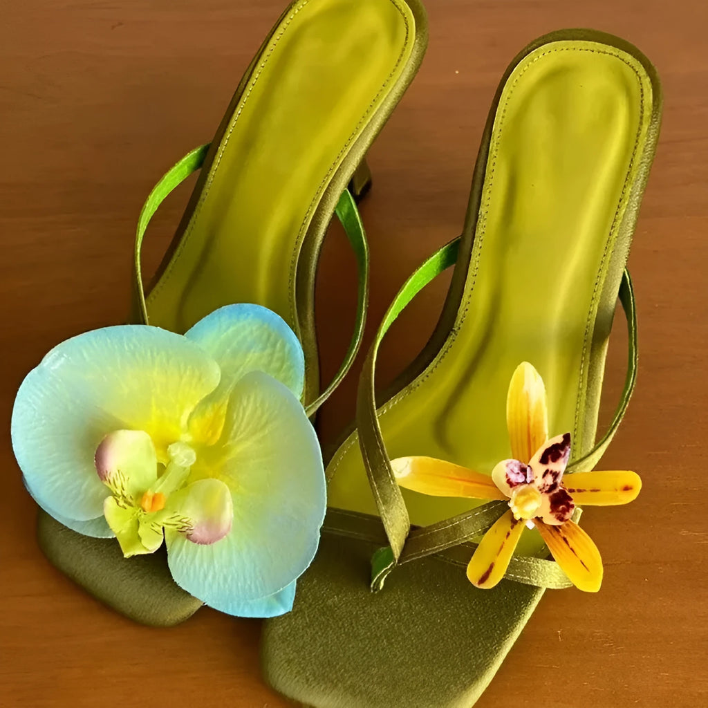 Handmade women's asymmetric flower sandals with high heel and square toe in black leather.