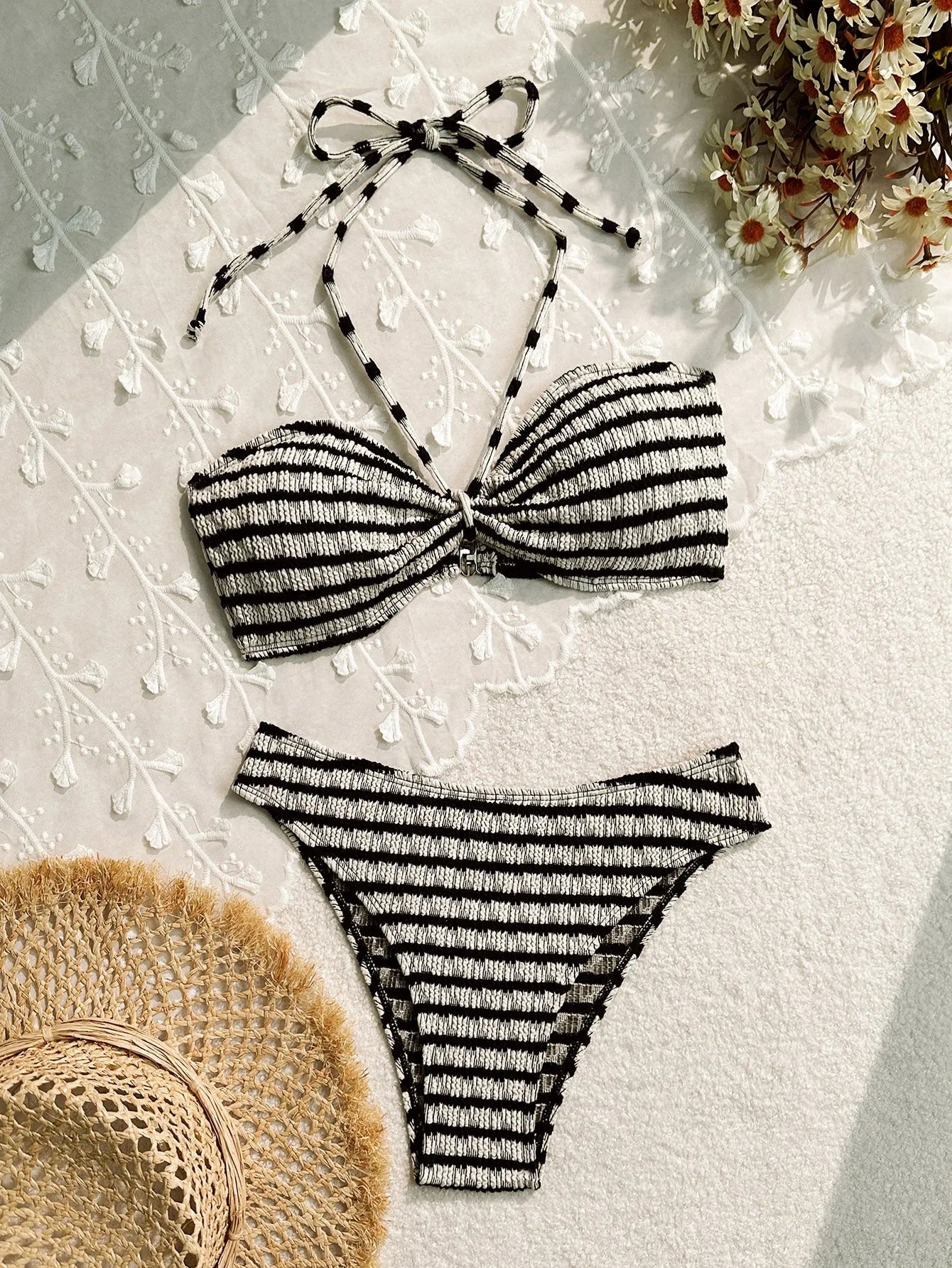 Women's pink and black striped printed bikini swimsuit on a hanger.