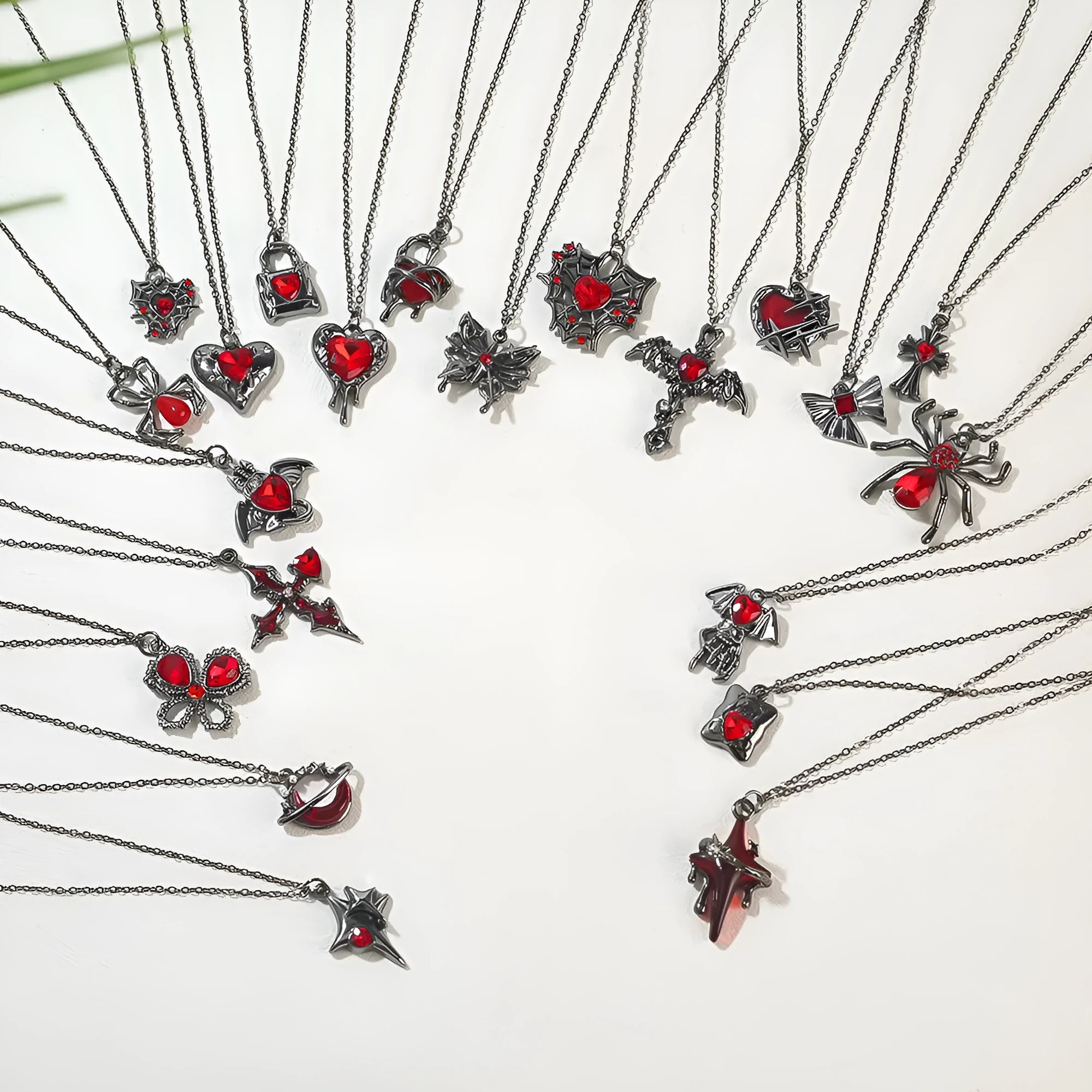 Halloween necklace with spider, bat, cross, and heart charm pendants on a metal chain.