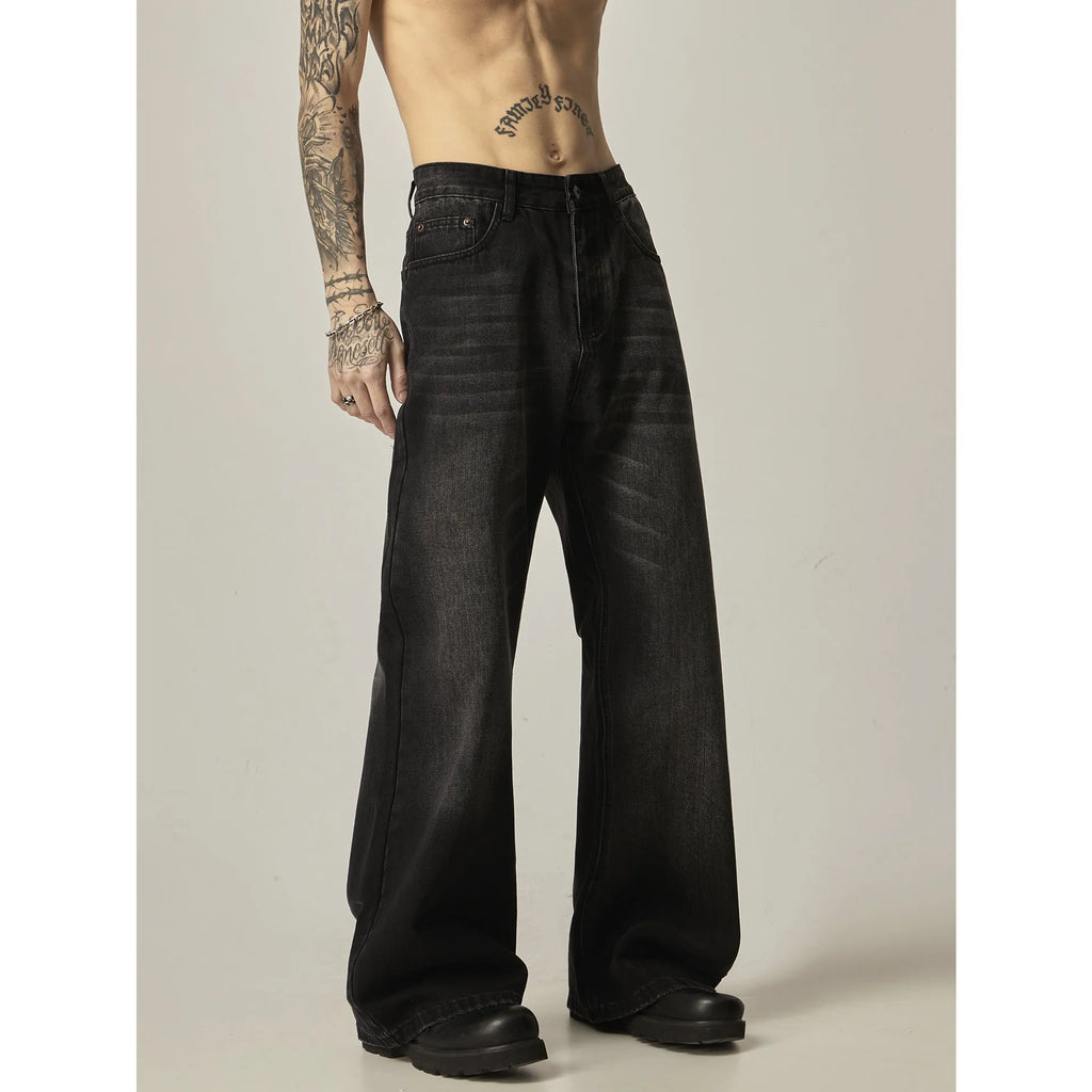 Black loose-fit straight leg denim jeans with a zipper fly on a neutral background.