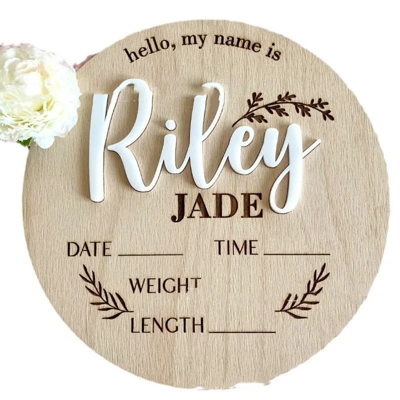 Personalised square wooden baby name plaque showing engraved birth details, in a rustic style, against a nursery background.