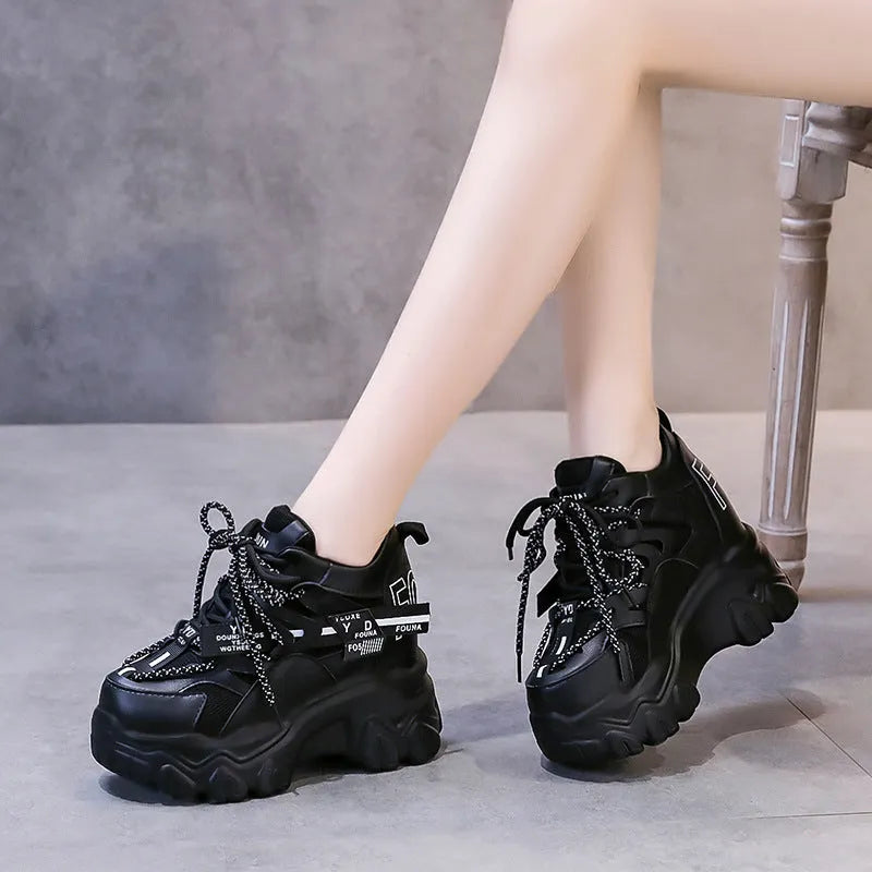 Women's white low-top platform sports shoes with a mesh upper and cross-strap detail.