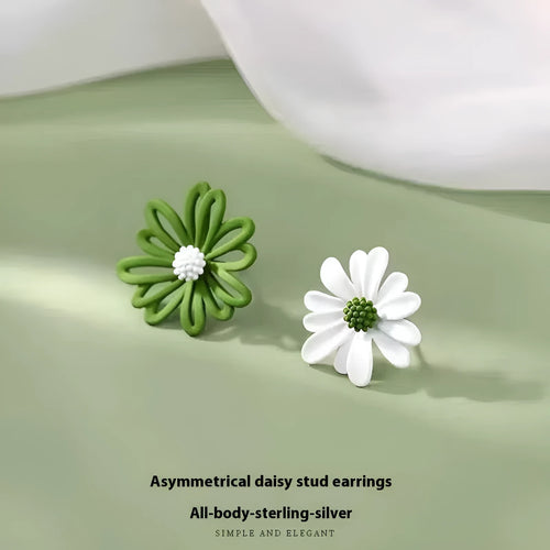 Close-up of colourful alloy flower stud earrings showing white and green two-tone design.