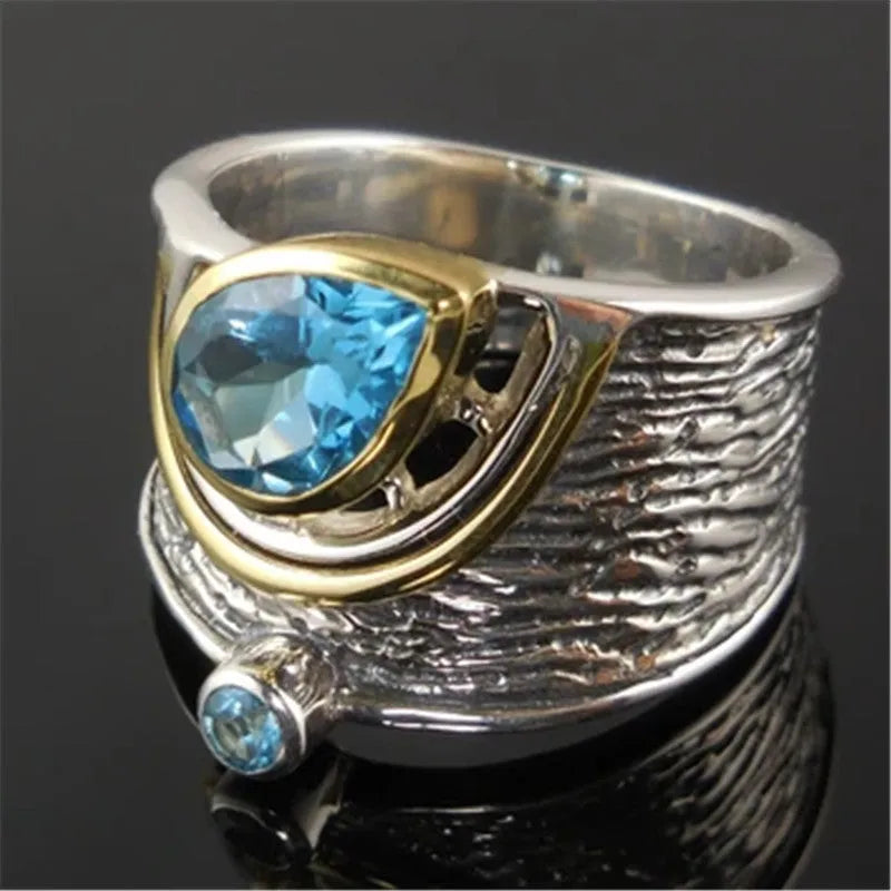 Blue drop-shaped zircon ring with Chinese-style design on a model finger.
