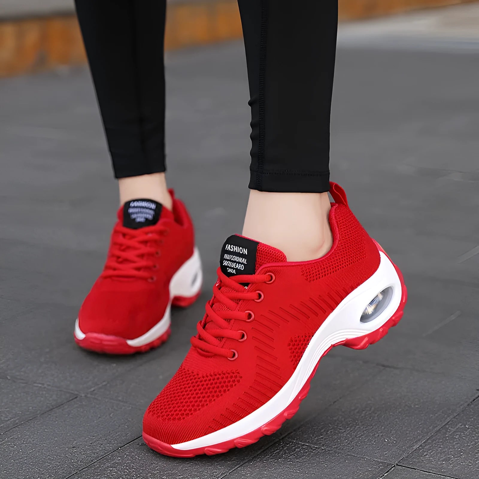 Women's red low-top mesh sneakers with front laces and a flat heel on a white background.