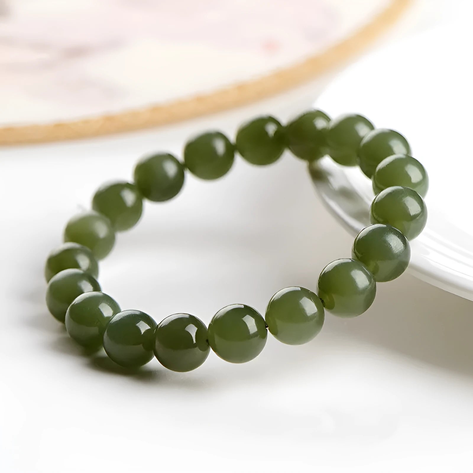 Polished Hetian jade bead bracelet in light or deep clear water colour on a wrist.