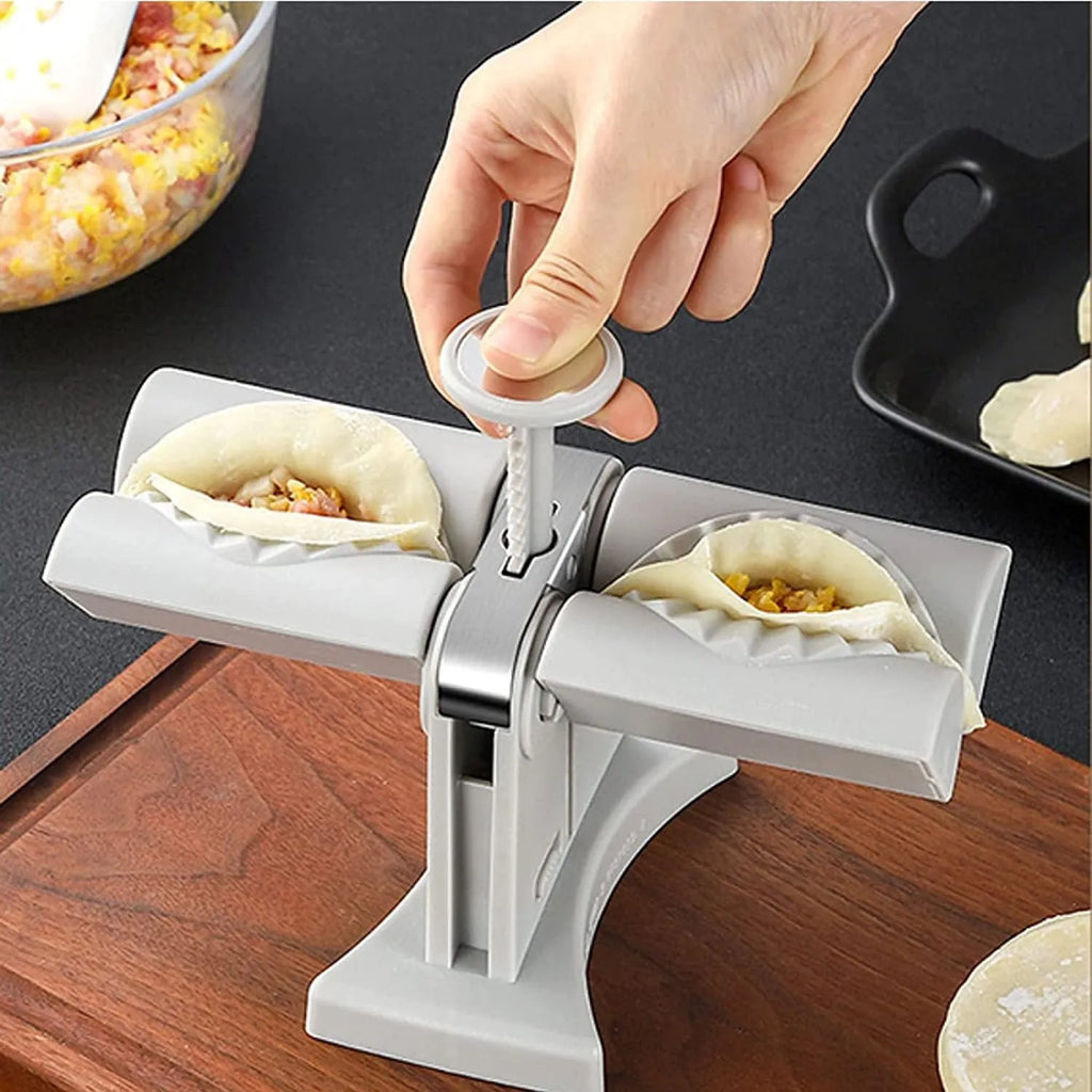 White plastic manual dumpling maker with double head press and anti-slip rubber base mat.