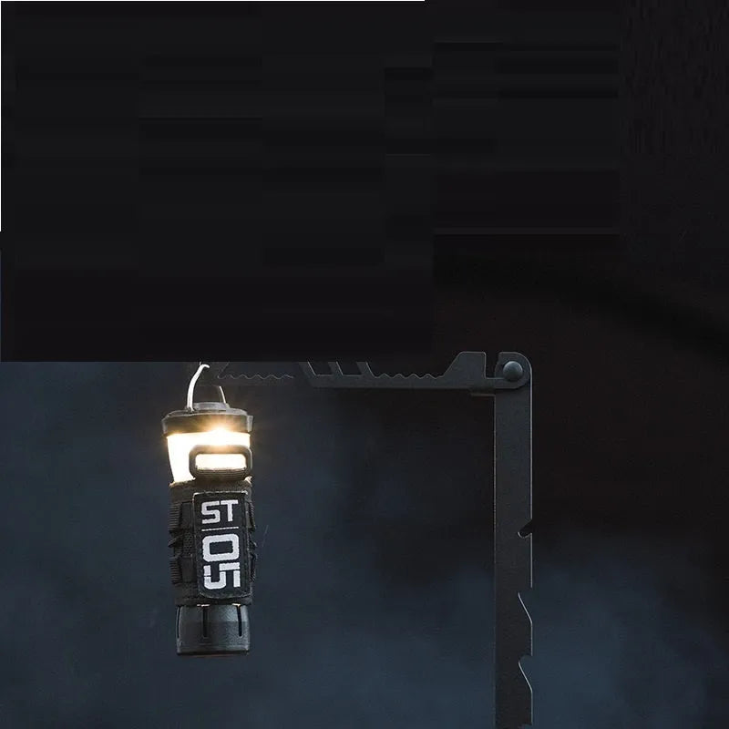 Black stainless steel telescopic lamp holder with gear adjustment mechanism on a desk edge.