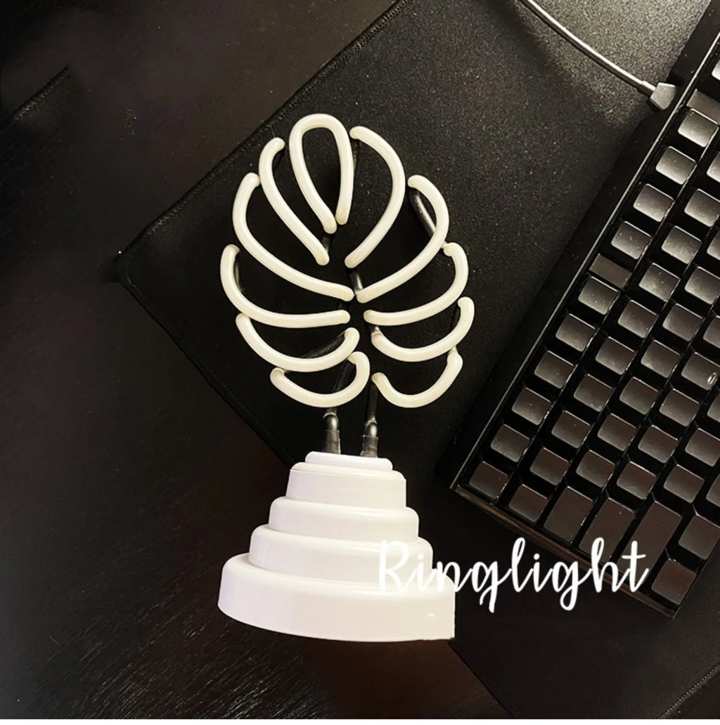 Minimalist white bamboo-shaped desktop lamp with a green glow, shown in two size options.