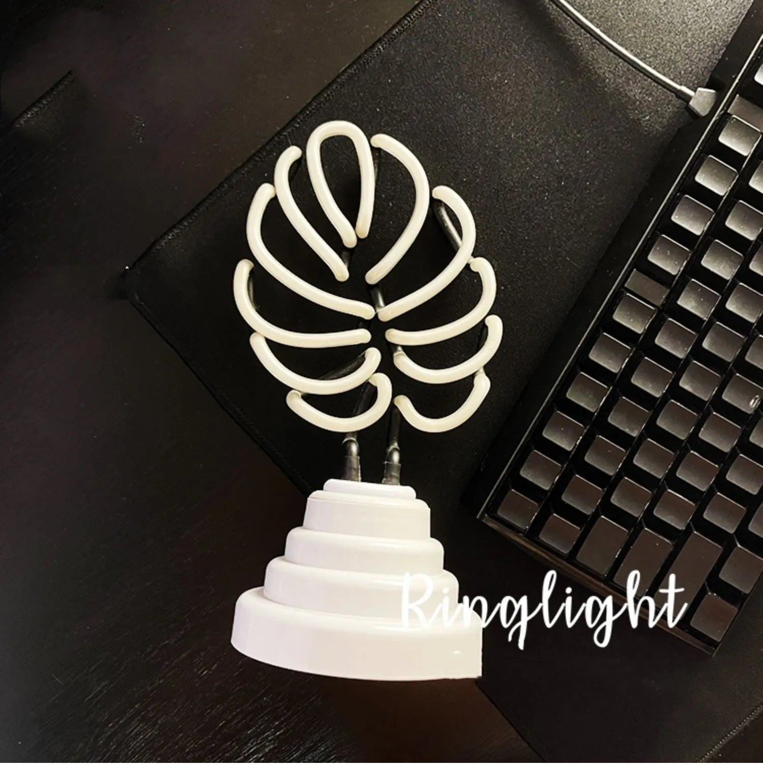 Minimalist white bamboo-shaped desktop lamp with a green glow, shown in two size options.