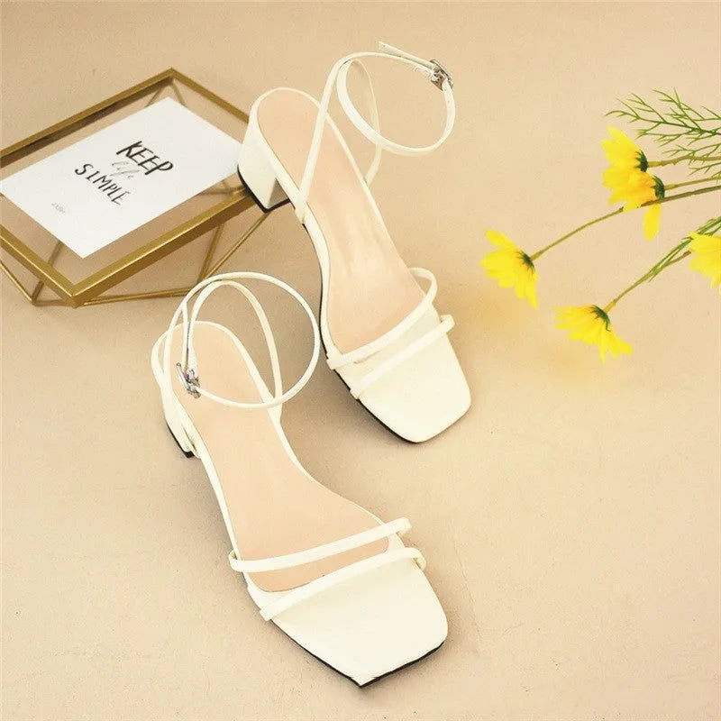 Beige women's stiletto sandals with chunky heel, square toe, and ankle buckle.