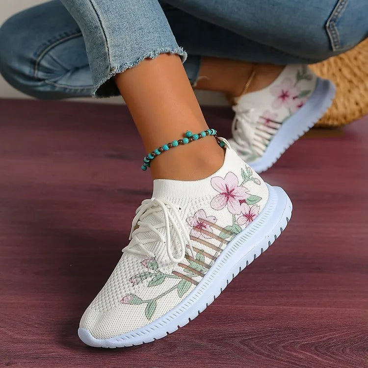 Women's milky white mesh flyknit running shoes with flat heel and rubber sole on grey background
